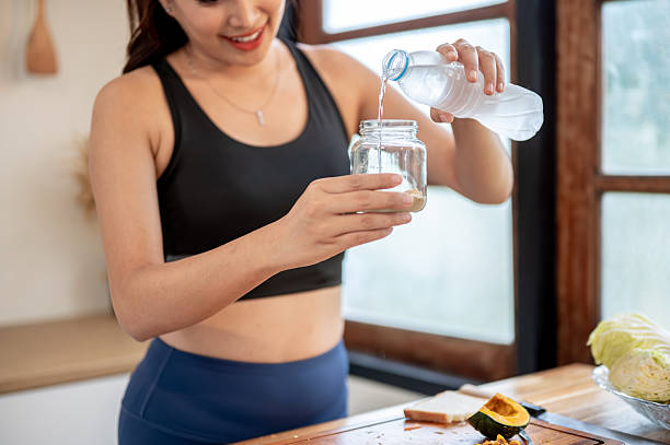 istock Asian woman adding pouring water in jar making protein powder shake drink at kitchen cooking counter 2245923217