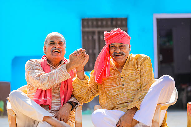 Two indian old farmer discussing at out of home.