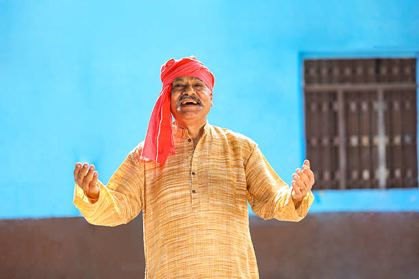 Old and senior indian farmer standing and giving happy expression