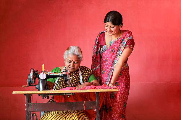 Indian rural woman using sewing machine at home