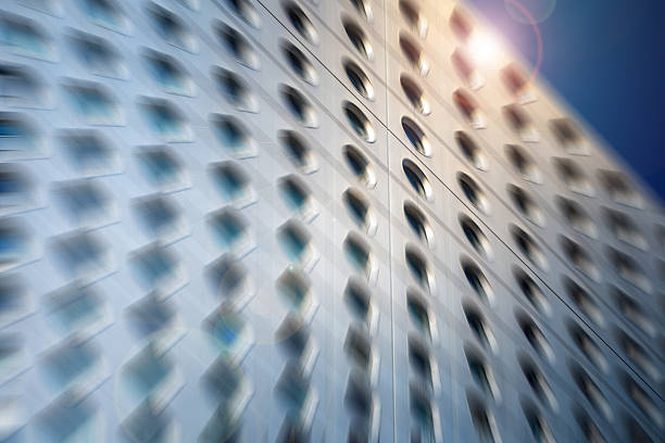 A modern architectural urban building facade is captured with a dynamic radial blur, creating a sense of rapid motion and energy.