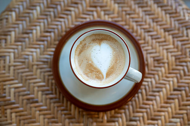 A cup of coffee placed on top of a rattan table