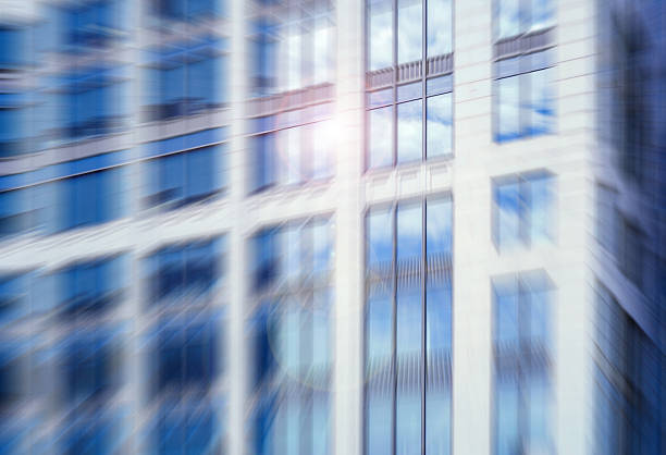 istock An architectural urban high-rise with reflective windows, captured with a dynamic radial blur effect and a sun flare. 2245938836