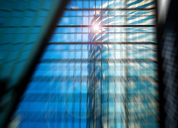istock Blurred urban architecture with blue glass and a bright sun glare, featuring a dynamic radial blur effect. 2245939443