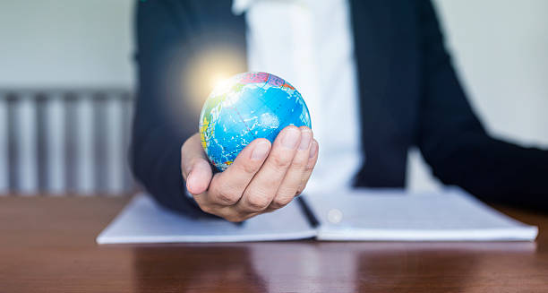 istock Business girl holding globe with flare light, business people holding globe 2245942657