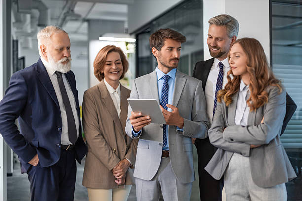 istock Business people discussing work together using a tablet and laptop taking notes in a modern office 2245943671