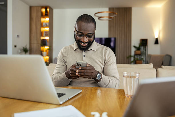 istock African american man smiling, typing on smartphone at home 2245944759