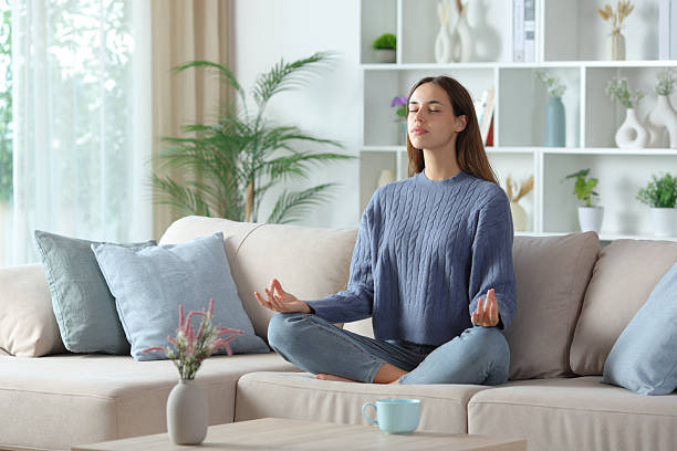 istock Casual woman in blue doing yoga exercise on a couch 2245944887