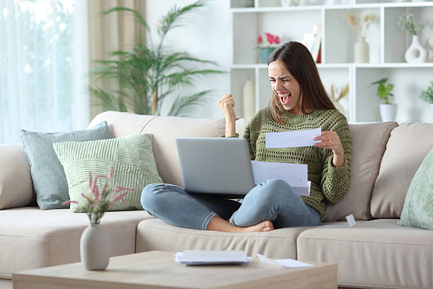 istock Excited woman in green checking bill online 2245944906