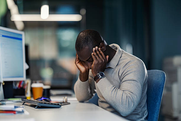 istock Stressed businessman suffering headache at office desk 2245945029