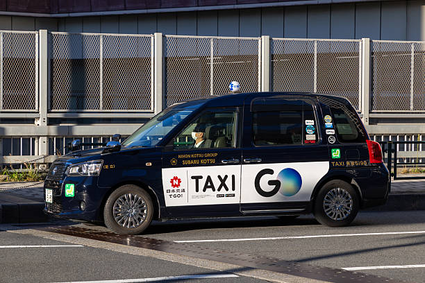 Tokyo (Japan) 28 May 2024: a classic Japanese Taxi travelling in a Tokyo street. The is the newest version of the Toyota Taxi introduced some years ago.