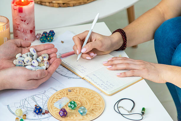 istock Numerology Divination consultation: woman writing in a notebook, man holding fortune stones. 2245945769