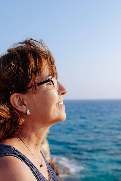 istock Smiling Woman Enjoying Ocean View at Sunset 2245950986