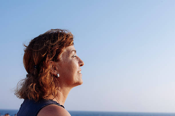 istock Smiling Woman Enjoying Ocean View at Sunset 2245951001