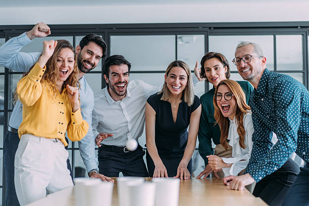 istock Young colleagues playing beer pong in the office. 2245952635