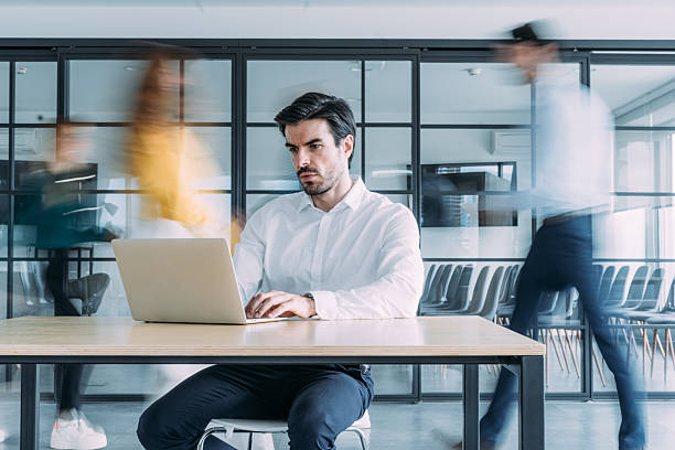 istock Businessman working on laptop in a busy office. 2245952640