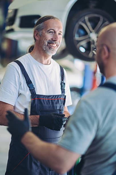 istock Smiling mature mechanic talking to a colleague 2245952682