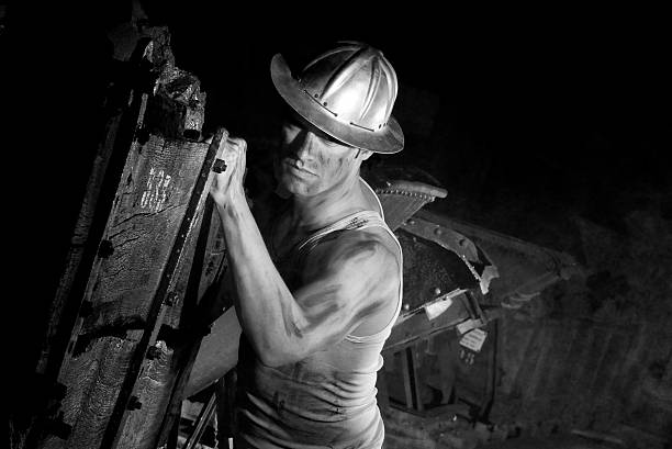 istock Miner working hard in dark underground tunnel 2245952735
