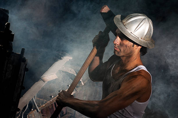 istock Laborer holding heavy hammer tool in dusty industrial setting 2245952750