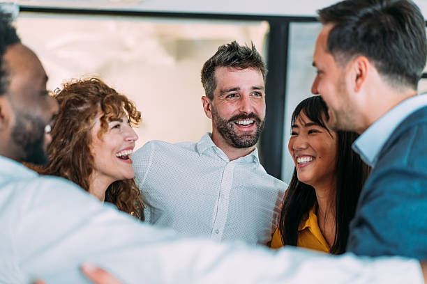 istock Excited coworkers embracing each other during a celebration in the office. 2245953915