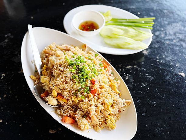 istock Fried rice with pork and vegetable in white plate on black background 2245954045