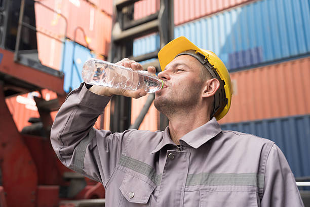 istock Male worker drinking water from plastic bottle at container yard. Male worker resting and break time at work 2245956679