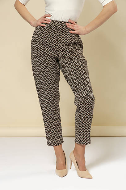 istock Studio photography of young female model wearing comfortable cigarette brown patterned cropped trousers and nude high heels 2245958881
