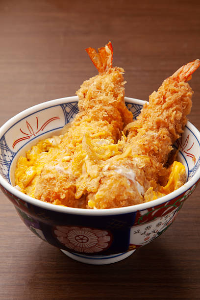 Rice bowl topped with fried shrimp and scrambled eggs