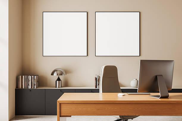 istock Modern office interior with desk and computer in front of two blank square posters on beige wall, minimalist design mockup template concept scene. 3D Rendering 2245959114