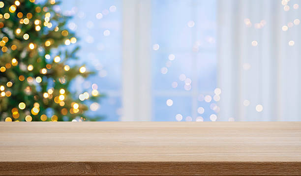 istock Christmas table top for product display on blurred fir tree lights and festive window interior background 2245960427