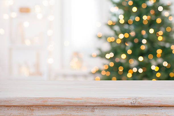 istock Bleached wood table top for your product presentation on deeply blurred Christmas fir tree lights interior background 2245960457