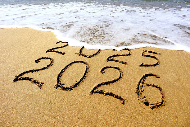 istock New year 2026 and 2025 on sandy beach with waves 2245960770