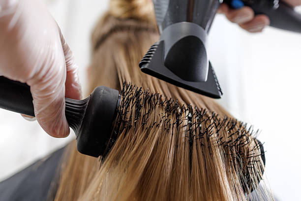 istock Round brush blowout with concentrator nozzle creating smooth volume in a salon 2245960889