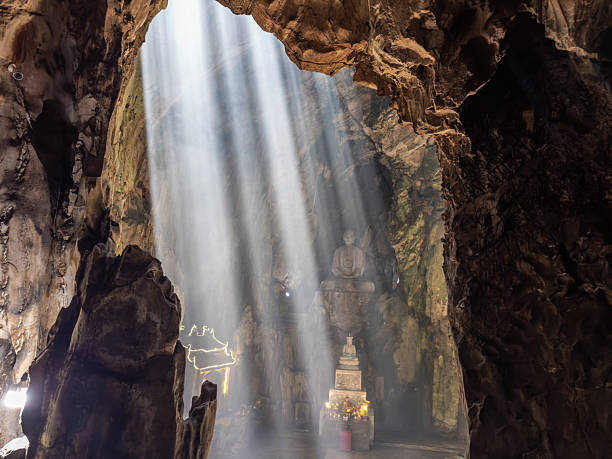 istock Dramatic sunbeams pierce through the cave ceiling, illuminating ancient Buddha statues and a sacred shrine within Huyen Khong Cave at Marble Mountains, Da Nang, Vietnam. A spiritual and mystical 2245962758