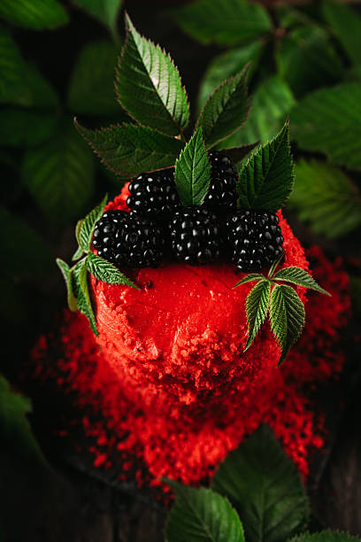 Red blackberry cake on dark wooden background