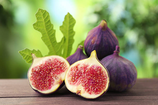istock Fresh ripe figs and green leaf on wooden table outdoors, closeup 2245972700