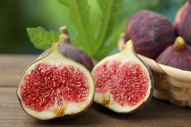 istock Fresh ripe figs and green leaf on wooden table outdoors, closeup 2245972740