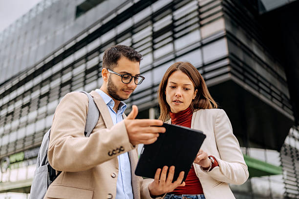 istock Two business colleagues using digital tablet outdoors 2245973057