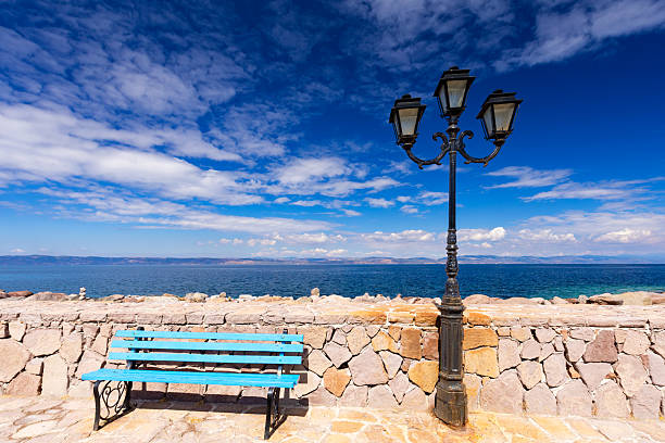 Blue Bench and Lamp Post by the Sea under a Clear Blue Sky on the Greek volcanic island of Lesbos, background or wallpaper from project