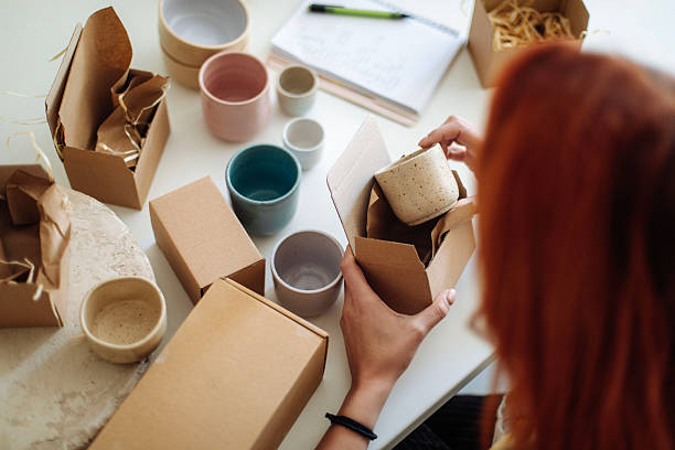 istock female ceramic artist packing handmade mugs in studio 2245973809
