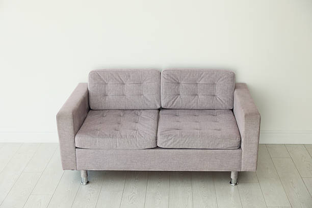 istock Comfortable gray sofa near white wall in room 2245975512