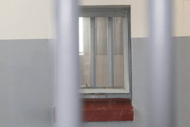 istock Peering through prison bars on to further cells - security and protection. 2245975655
