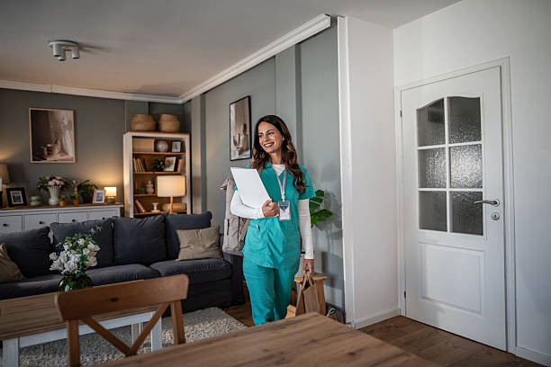 istock Smiling nurse delivering home care services with documents 2245980653