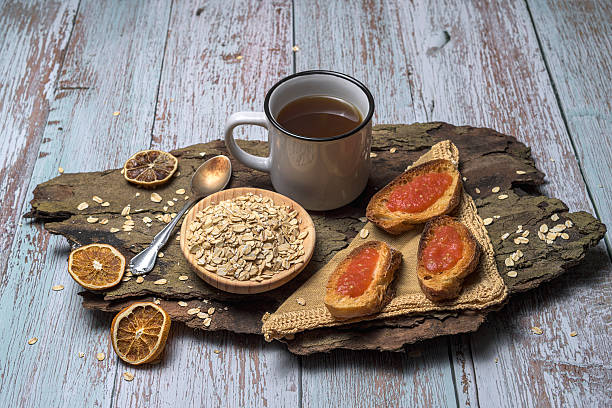 a jar of Quince  jam with breads  and butter on wood cutting board