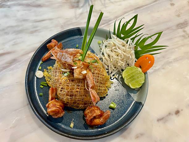 istock Fried noodle Thai style with prawns and vegetables on a plate 2245985823