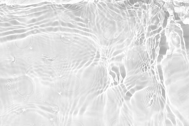 istock White water with ripples on the surface. Defocus blurred transparent white colored clear calm water surface texture with splashes and bubbles. Water waves with shining pattern texture background. 2245986302