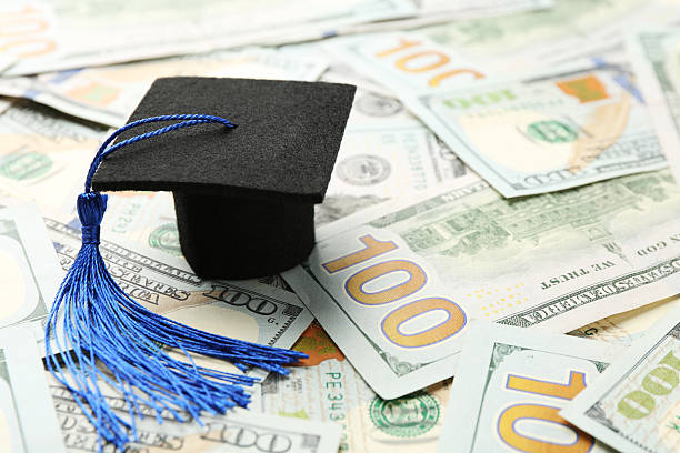 istock Scholarship. Graduate hat on dollar banknotes, closeup. Space for text 2245989709