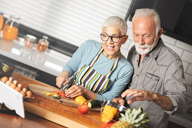 istock Happy mature couple using touchpad while preparing food in the kitchen 2245990961