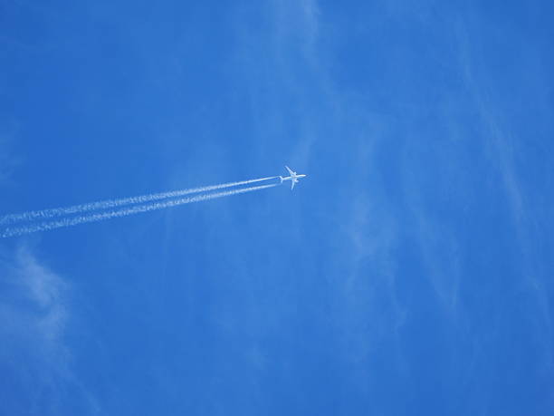 istock Airplane with contrails in clear blue sky 2245990977