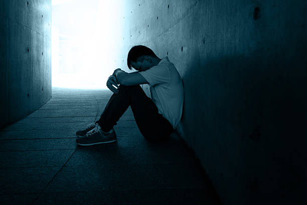 istock Sad man sitting on ground in a dark place 2245991028